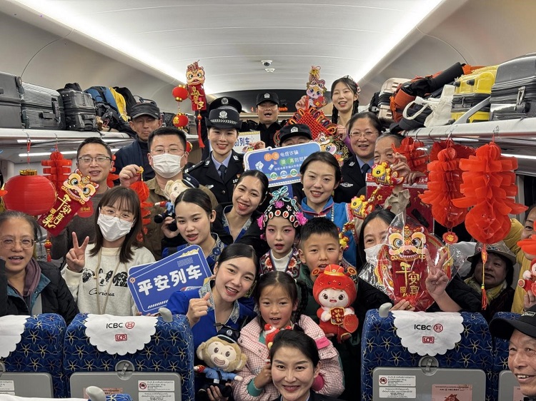 春節(jié)期間，在中老鐵路磨萬（磨丁—萬象）段，鐵路客運員工與乘客合影留念。李加勇攝