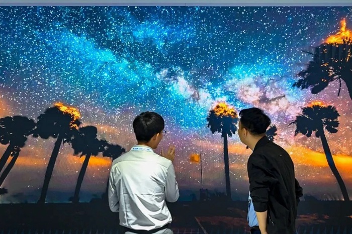長春光博會希達電子展區(qū)，一位工作人員正在給一位觀眾講解。（長春新區(qū)供圖）