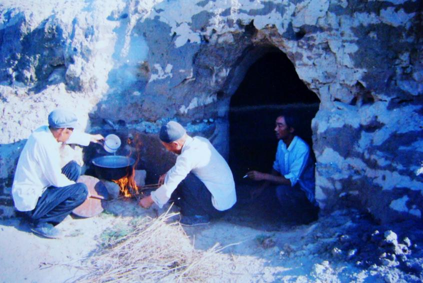 1983年，“六老漢”一代治沙人在“地窩子”生活做飯。新華社發(fā)（八步沙林場供圖）
