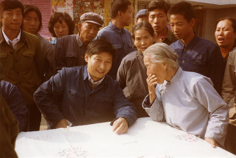 1983年，時(shí)任河北正定縣委書(shū)記的習(xí)近平（前排居中），臨時(shí)在大街上擺桌子聽(tīng)取老百姓意見(jiàn)。