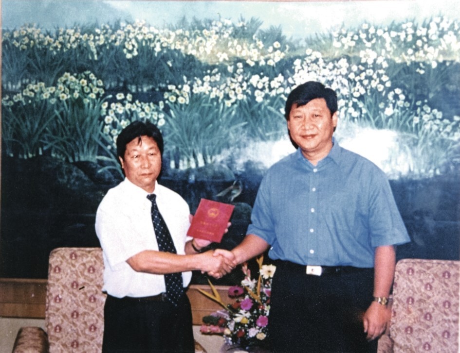 2000年7月，習近平為福建農(nóng)林大學教授林占熺頒發(fā)福建省政府“一等功”榮譽證書。圖源：《習近平在福建》（下）