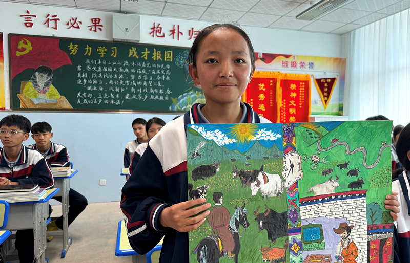 果洛西寧民族中學(xué)學(xué)生尼東拉毛在主題思政課上展示表現(xiàn)現(xiàn)代化家鄉(xiāng)的作品。