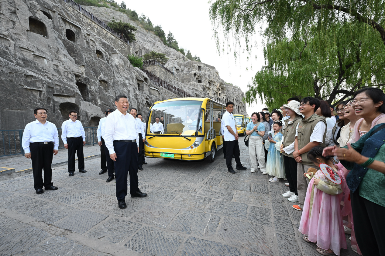 5月19日，習(xí)近平在洛陽龍門石窟考察時(shí)，同游客親切交流。