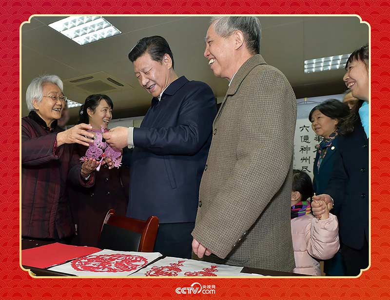 2015年2月15日，習(xí)近平在西安市雁塔區(qū)電子城街道二〇五所社區(qū)服務(wù)中心欣賞社區(qū)居民的剪紙作品。