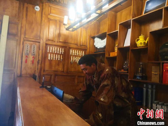 圖為桑杰才讓用電腦處理財(cái)務(wù)。　史靜靜 攝