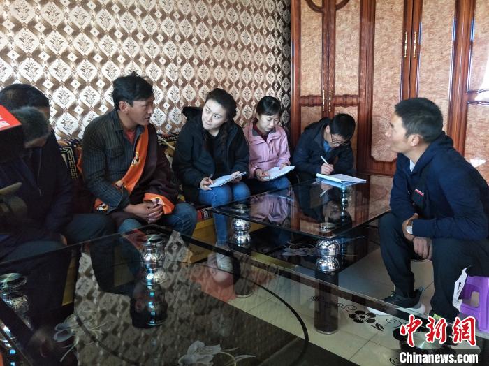 圖為調(diào)查組工作人員正在入戶調(diào)查?！∑钤鲚?攝