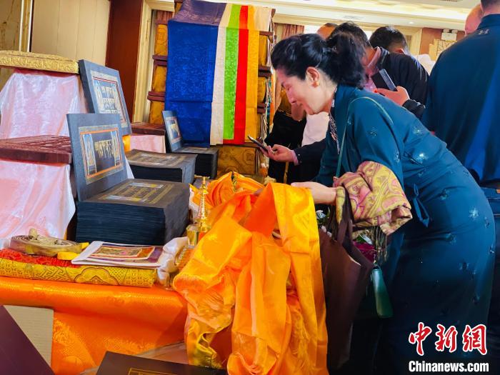 圖為現(xiàn)場藏族民眾向黃金書寫的大藏經(jīng)《甘珠爾》敬獻哈達?！O睿 攝