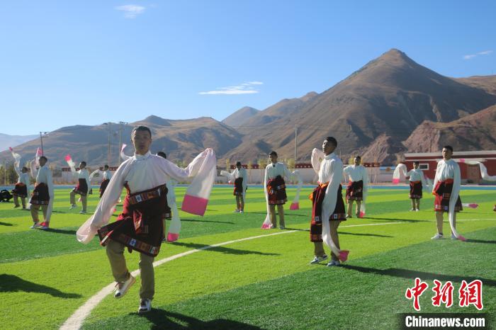 圖為青海師范大學(xué)附屬玉樹實(shí)驗(yàn)學(xué)校學(xué)生在綠茵場跳起囊謙古舞—卓根瑪?！〕逃?攝