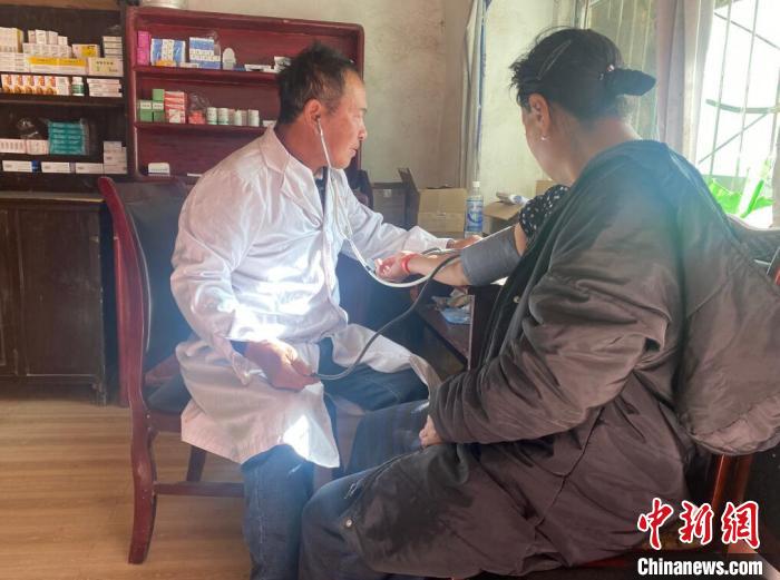 索木滾(左)為村民看病?！∪捞量h委宣傳部供圖