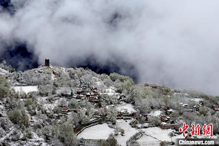 雪后的藏寨和碉樓構(gòu)成美麗的雪景?！〗党鯘衫?攝