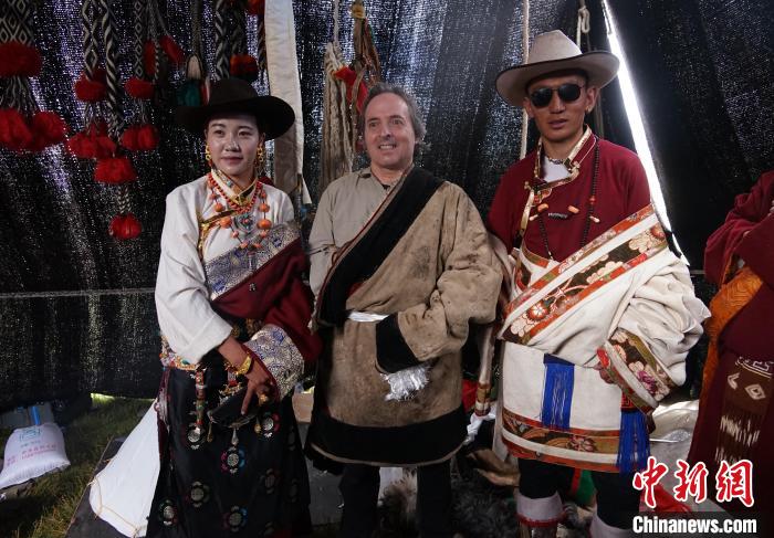 圖為一名外籍?dāng)z影師(中)身穿藏服和藏族民眾合影留念?！●R銘言 攝