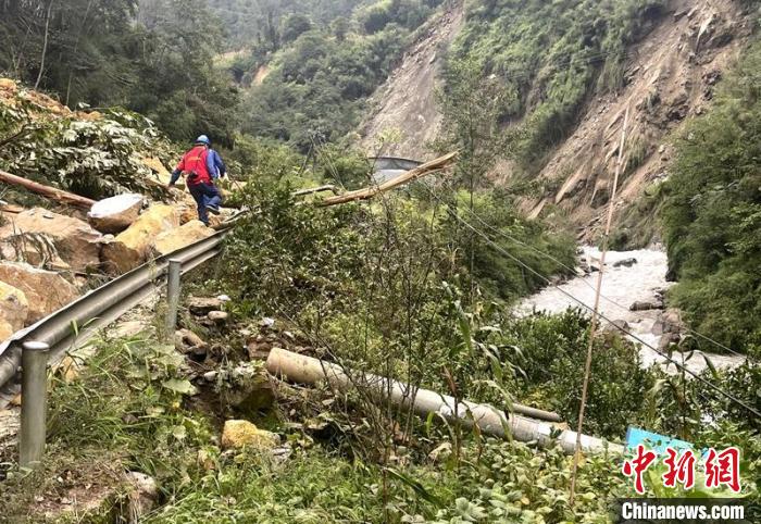 電力搶險人員快速通過危險路段，旁邊是受損的電力線路 四川電力供圖