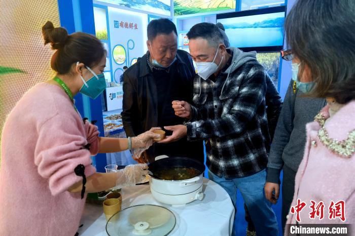 圖為杭州市民品嘗茶卡羊肉?！±铍h 攝