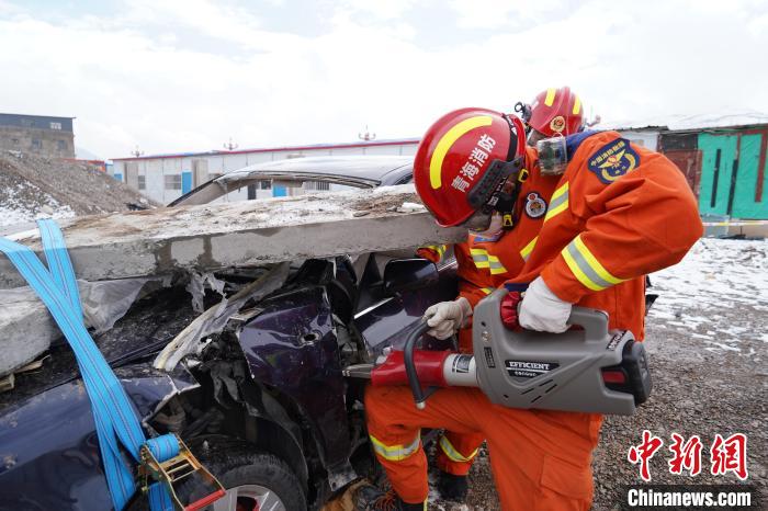 圖為地震實戰(zhàn)拉動現(xiàn)場，參演人員進行車輛破拆?！∮駱湎拦﹫D