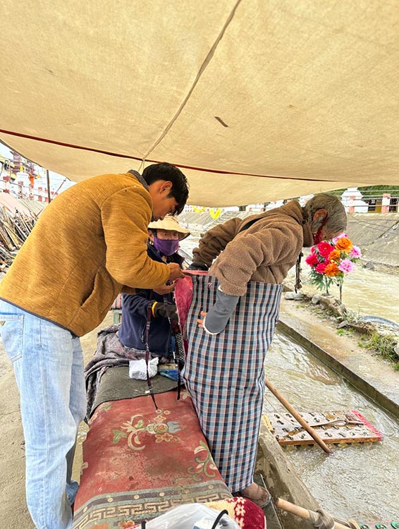 扎西奪爾登為路邊老人送去保暖圍腰。阿壩州文明辦供圖