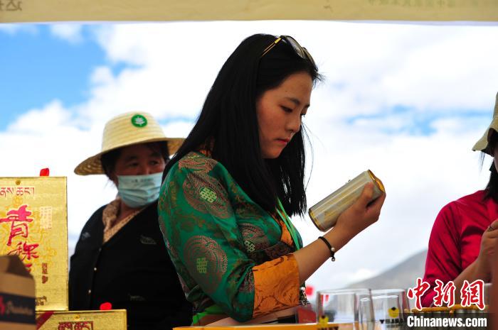 圖為拉薩市民在特色農(nóng)畜產(chǎn)品展示展銷會上選購商品?！垈?攝