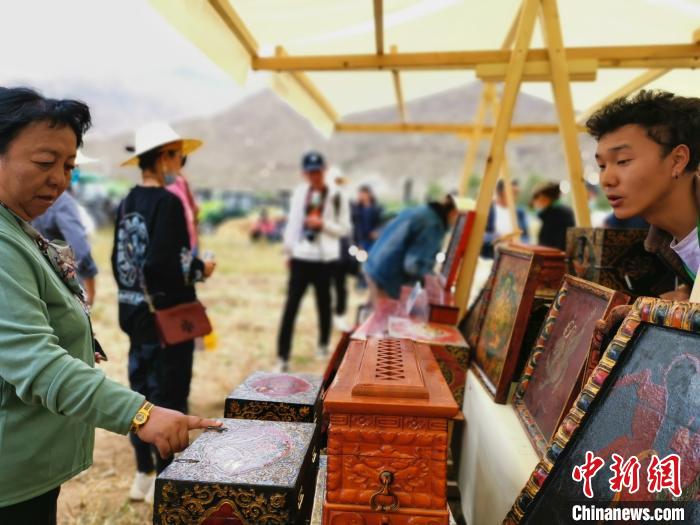 圖為拉薩市民在特色農(nóng)畜產(chǎn)品展示展銷會上選購商品?！垈?攝