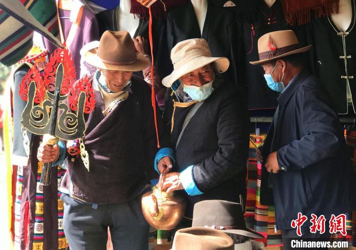 圖為三位藏族老人在集市上聊天交談?！∪轿木?攝