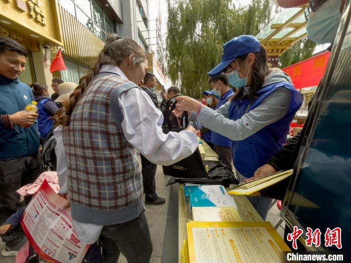 圖為志愿者為市民發(fā)放網(wǎng)絡(luò)安全宣傳手冊?！≈x牧 攝