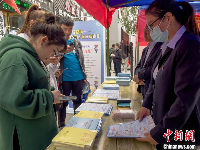 圖為工作人員正在向路過市民介紹國家反詐中心軟件的功能。　謝牧 攝