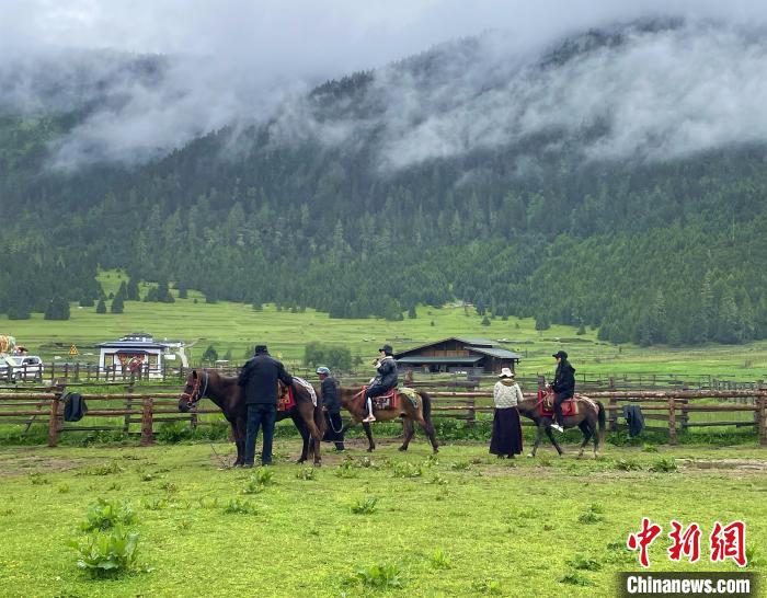 6月10日，游客在魯朗小鎮(zhèn)高山牧場(chǎng)景區(qū)體驗(yàn)騎馬?！∪轿木?攝