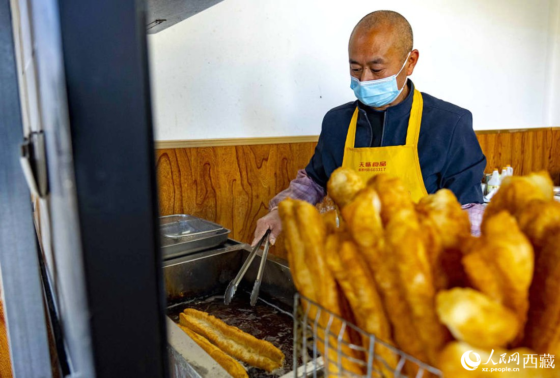 早餐店老板正在炸油條。人民網(wǎng) 次仁羅布攝