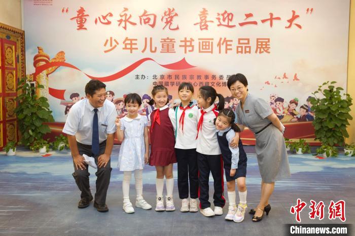圖為與會嘉賓與入選畫作的“小作者”們在展覽上合影?！≈袊貙W(xué)研究中心供圖