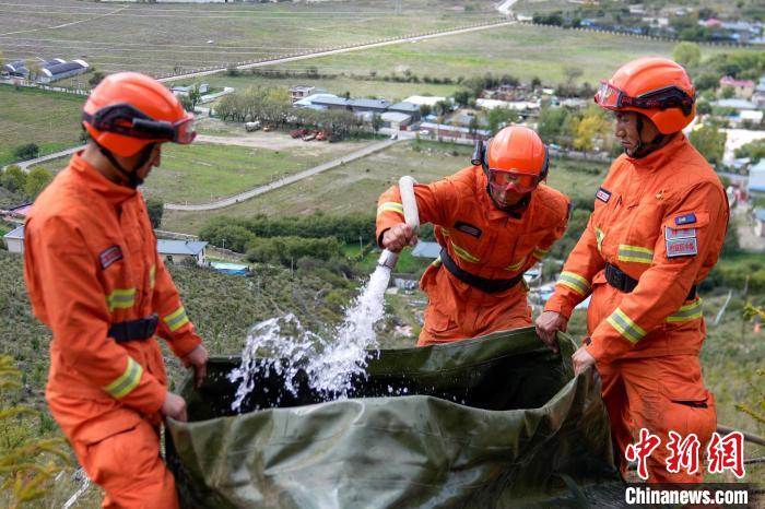 技能大練兵過程中，消防員在陡坡上向蓄水池注水?！±顕鵂c 攝