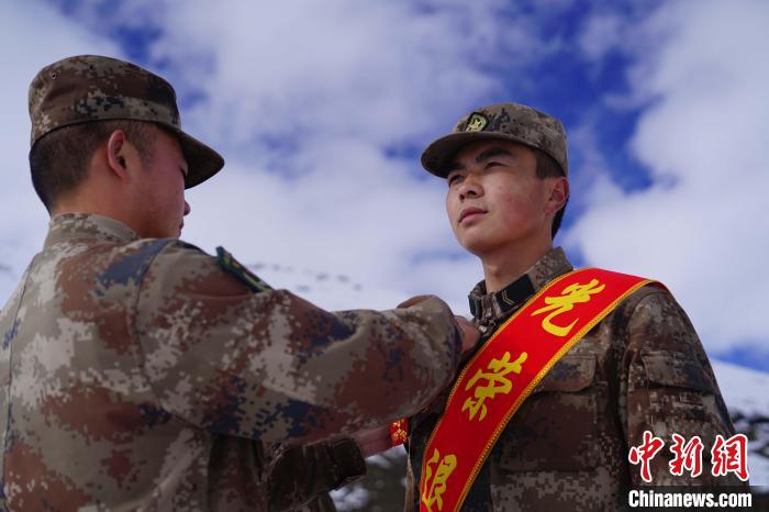 排長王朝偉(圖左)給退伍老兵佩戴大紅花?！∥鞑厣侥宪姺謪^(qū)某團(tuán)供圖