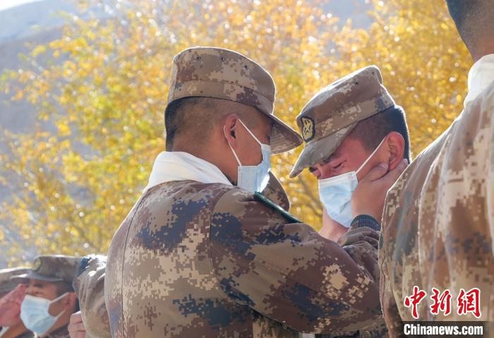 圖為什布奇邊防連退伍老兵與戰(zhàn)友相擁而泣，依依惜別?！⌒觳?攝