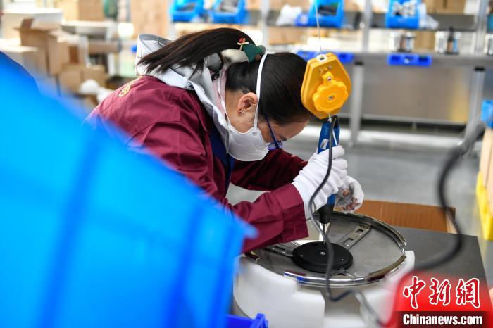 圖為工人正在組裝炊具?！∝暩聛硭?攝