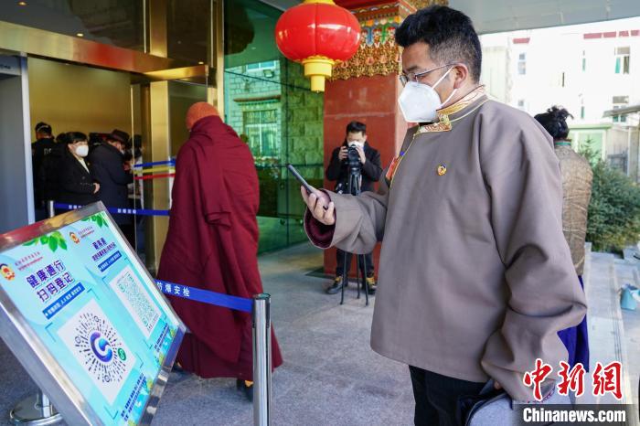 圖為政協(xié)委員掃場所碼進入會場。　江飛波 攝