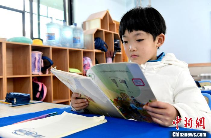 3月14日，西藏拉薩市第一小學(xué)一年級(jí)六班學(xué)生丁增樂(lè)吉在閱讀藏語(yǔ)課本?！±盍?攝