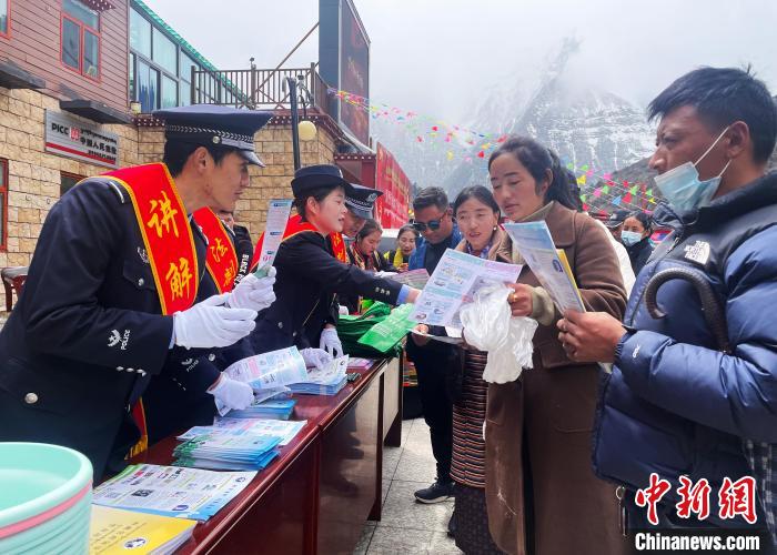 圖為山南玉麥邊境派出所民警為轄區(qū)群眾發(fā)放法律知識(shí)宣傳單?！＄婗?　攝