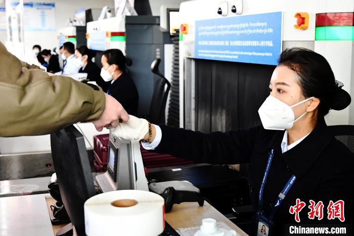 圖為機場工作人員為旅客辦理行李托運?！≈芎?攝