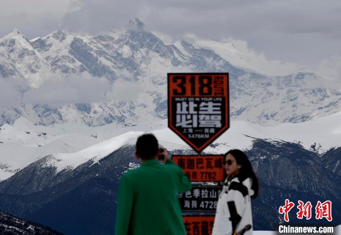 圖為5月14日，西藏林芝色季拉山觀景臺(tái)，游客遠(yuǎn)眺南迦巴瓦峰。　　李林 攝