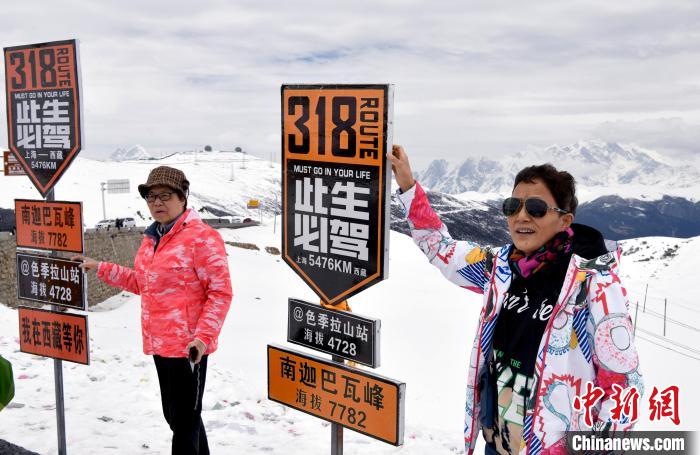 圖為5月14日，西藏林芝色季拉山觀景臺(tái)，游客與南迦巴瓦峰合影?！±盍?攝