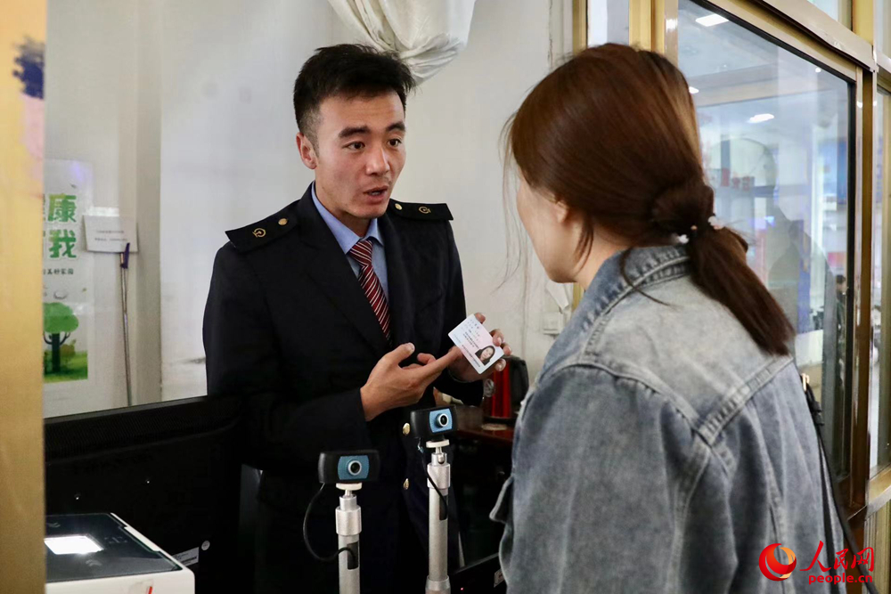 車站工作人員向旅客解答疑問。人民網(wǎng)記者 次仁羅布攝
