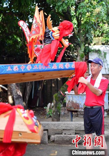 圖為5月29日，長樂江田鎮(zhèn)村民為即將入水的新龍舟系紅布?！埍?攝