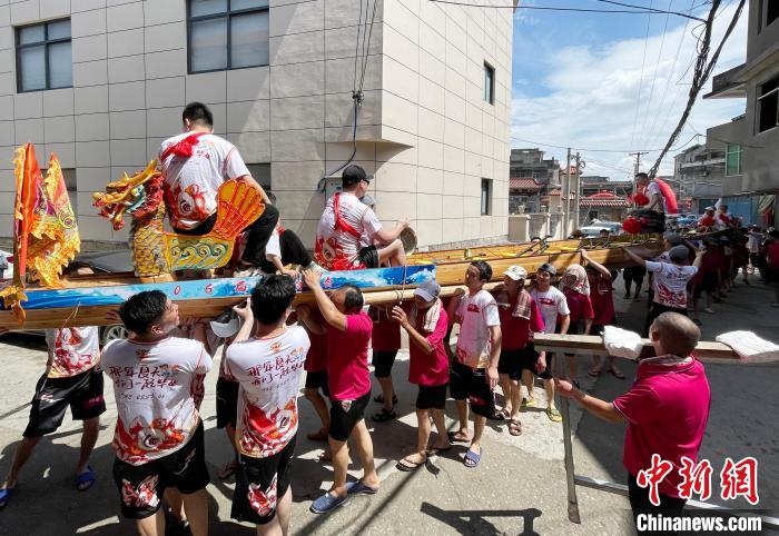 圖為5月29日，長樂江田鎮(zhèn)村民們肩扛著新龍舟舉行入水前游街儀式。　張斌 攝