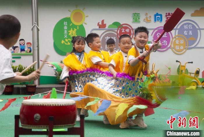 圖為龍舟賽游戲上，小伙伴們打鼓加油?！《^生 攝