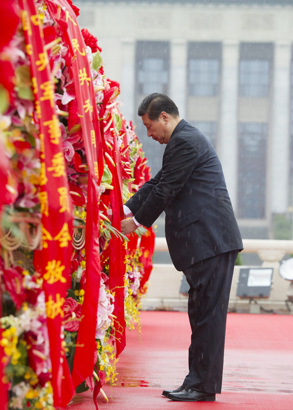 2013年10月1日上午，在首都各界代表向人民英雄紀(jì)念碑敬獻(xiàn)花籃儀式上，習(xí)近平整理花籃上的緞帶。