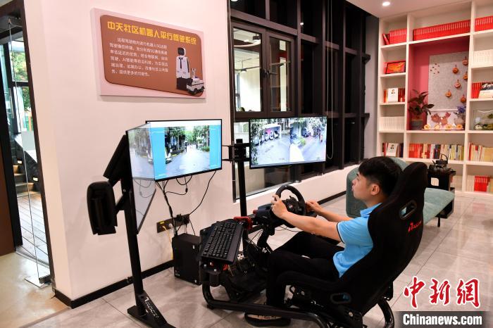 圖為福州中天社區(qū)工作人員正在利用5G技術(shù)，遠(yuǎn)程操控機(jī)器人巡視社區(qū)。　呂明 攝